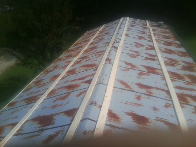 Rusted metal roof panels with new wood purlins before replacement — Storm Damage Roof Repair in Port Henry by Roofing Brothers